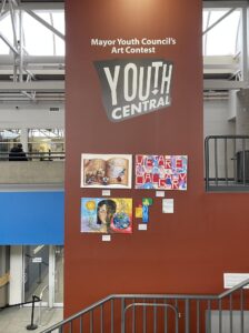 Art pieces from the Mayor's Youth Council's Art contest hang on a wall at Southland Leisure Centre