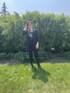 Alex S standing in front of greenery 